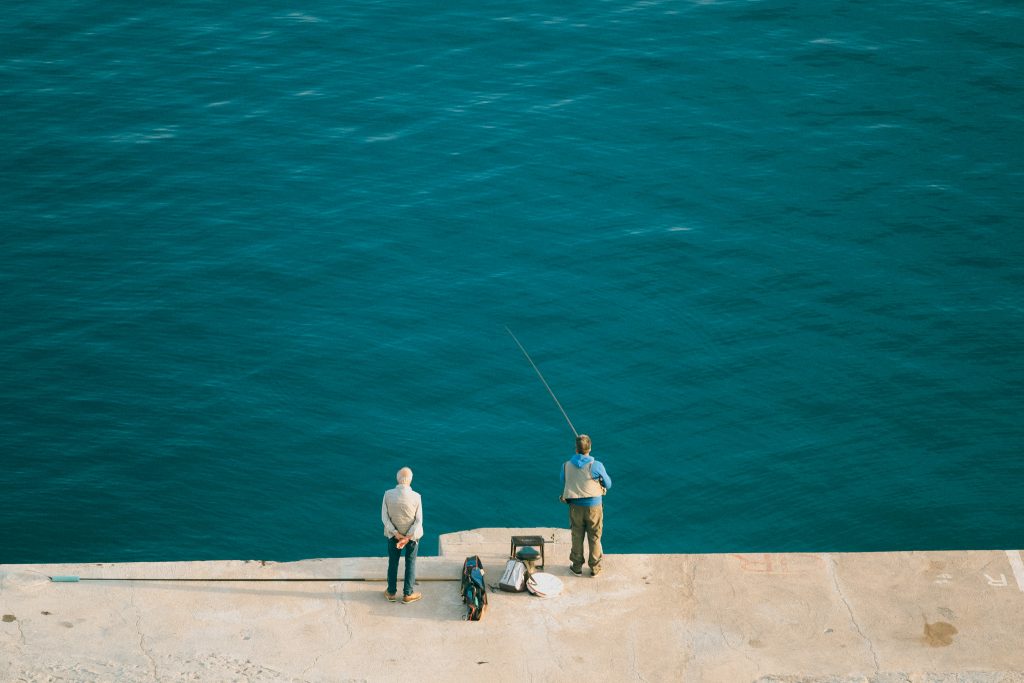 pêcheurs sur la jetée du port de calvi en balagne, corse
